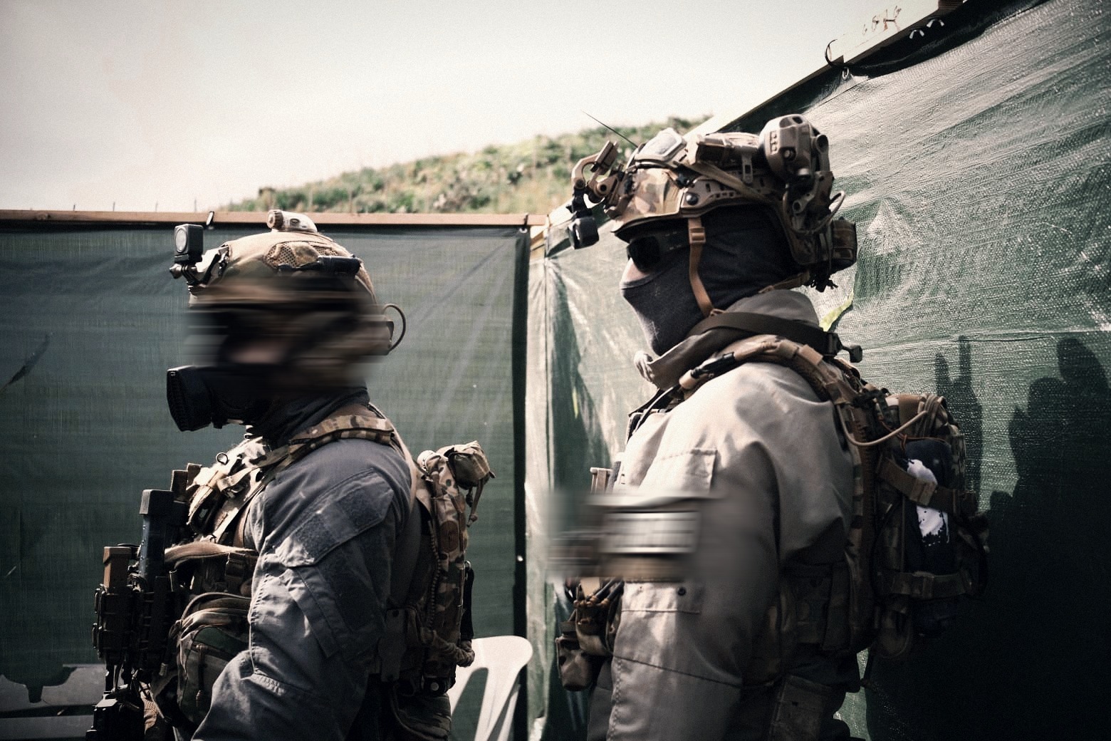 Operators in gas masks and tactical kit during outdoor live-fire training